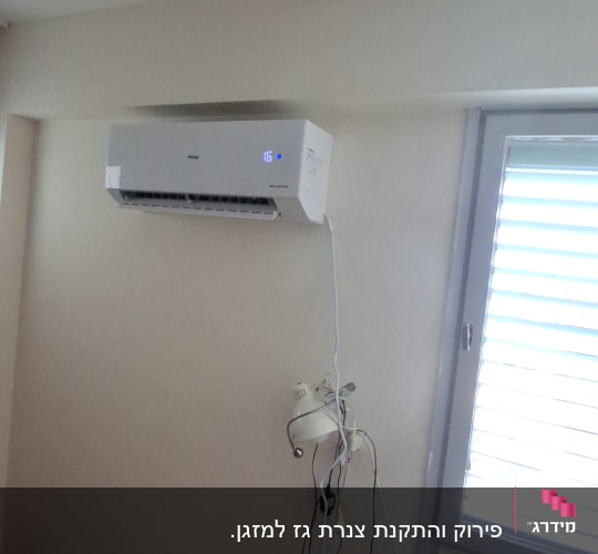 מזגן מותקן על קיר בחדר עם חלון